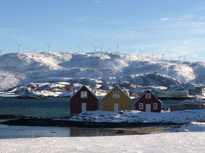 Red cabins on a snowy shore in the fjords outside Tromsø